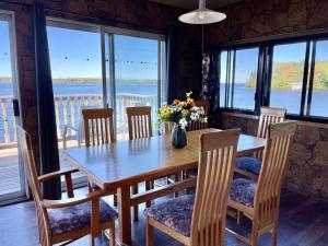 Una mesa de comedor y sillas con vista al agua. en Upper Boathouse on Balsam Lake #1, en Kawartha Lakes