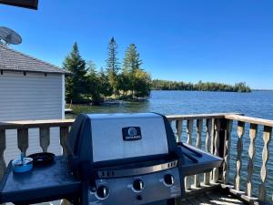 Una parrilla de barbacoa situada en una terraza junto al agua. en Upper Boathouse on Balsam Lake #1, en Kawartha Lakes