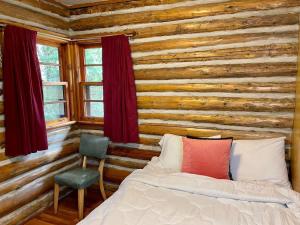 Un dormitorio con una cama y una pared de madera. en Balsam Lake - 2-Bedroom House in Kawartha #15, en Kawartha Lakes