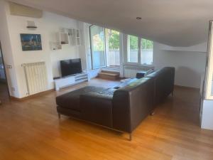 un salon avec un canapé noir et une télévision dans l'établissement La Magnolia B&B, à Montesilvano