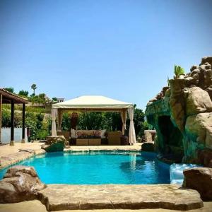 una piscina en un patio trasero con una pared de roca en Angels Cabin, en San Bartolomé