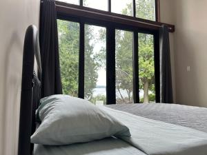 a bed with a pillow in front of a window at 3-bedroom Lakefront Villa #9 in Lakefield