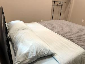 Una cama con sábanas blancas y almohadas. en 3-bedroom Lakefront Villa #6, en Lakefield