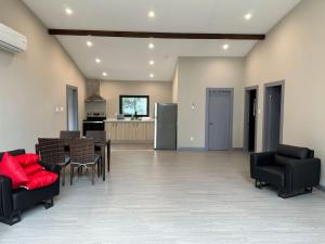 a large living room with black chairs and red pillows at 3-bedroom Lakefront Villa #5 in Lakefield