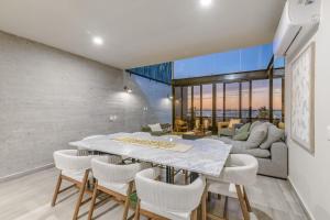 a dining room and living room with a table and chairs at Penthouse Vista al Mar, Gimnasio, Terraza, Alberca in La Paz