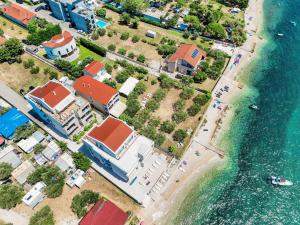widok z lotu ptaka na plażę z domami i wodą w obiekcie DʻArt Villa w Bibinje