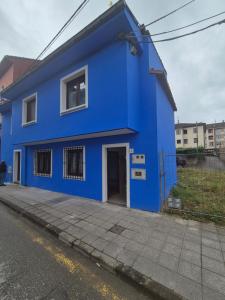 a blue house on the side of a street at 22A04 Casa Azul del corral de abaju en Arriondas in Arriondas