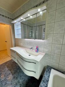 a bathroom with a white sink and a mirror at ausZEITlarn - Apartment in Zeitlarn +19 photos