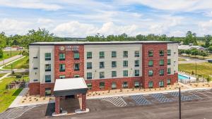 una vista aérea de un edificio con un cartel en un estacionamiento en Cobblestone Hotel & Suites - Foley, en Foley