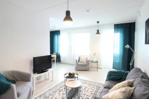 a living room with a couch and a tv at Spacious Apartment for 4 in Kivistö