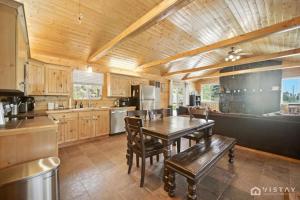 - une cuisine avec un plafond en bois, une table et des chaises dans l'établissement Stunning Log Cabin Close to Panguitch Lake, à Panguitch