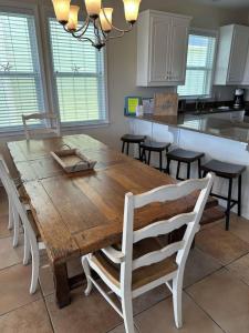 a kitchen with a wooden table and some chairs at Barefoot Breeze,Steps To The Beach ,Pool ,Sleeps 13, Seacrest in Seacrest +18 photos