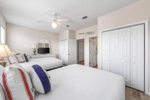 a bedroom with two white beds and a ceiling fan at Barefoot Breeze,Steps To The Beach ,Pool ,Sleeps 13, Seacrest in Seacrest