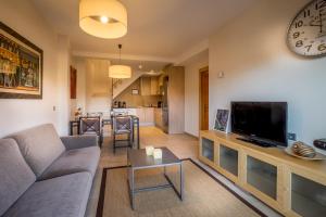 a living room with a couch and a tv at Can Tarongeta Apartments in Palafrugell
