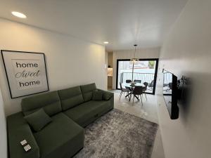 ein Wohnzimmer mit einem grünen Sofa und einem Esszimmer in der Unterkunft Casa do Lago das Freiras in Ribeira Grande