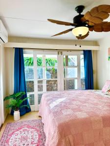 Schlafzimmer mit einem Bett, einem Deckenventilator und Fenstern in der Unterkunft Oceanfront Stay w/ AC, BBQ, Washer/Dryer & Kitchen in Ewa Beach