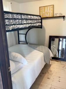 a bunk bed in a room with a mirror at Muskoka Cabana - Sandy beach cottage in Muskoka in Windermere