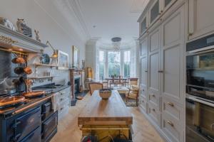 una gran cocina con una mesa en el centro en Luxury West End flat with stunning bay window views, en Edimburgo