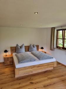 Un dormitorio con una gran cama de madera en una habitación. en Landhaus Poppler mit Aufzug, en Hopferau
