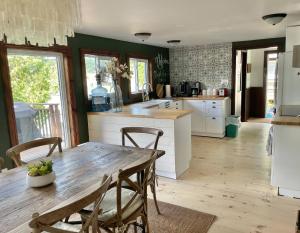 a kitchen with a wooden table and chairs in it at Muskoka Cabana - Sandy beach cottage in Muskoka in Windermere +27 photos