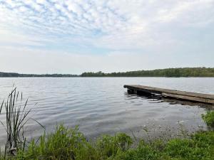 a dock on a lake with trees in the background at 3-bedroom Lakefront Villa #3 in Lakefield