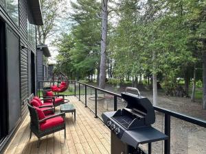 a porch with chairs and a grill on a house at 3-bedroom Lakefront Villa #3 in Lakefield