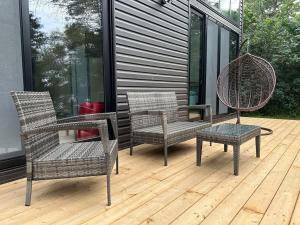 three wicker chairs and a table on a deck at 3-bedroom Lakefront Villa #10 in Lakefield