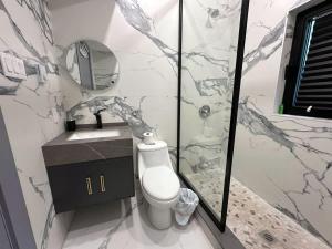 Un baño con inodoro, lavabo y espejo. en 3-bedroom Villa in Lakefield #11, en Lakefield 11 fotos más
