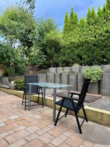 een glazen tafel en 2 stoelen op een patio bij ausZEITlarn - Apartment in Zeitlarn +19 foto's