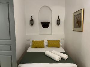 Un dormitorio pequeño con una cama con dos almohadas. en Dar Sharqi, Authentic Riad with Panoramic Sea View in Tangier, en Tánger