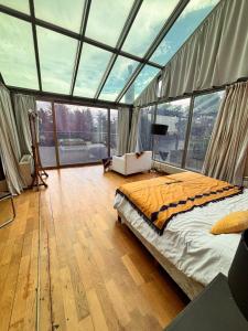 a bedroom with a bed in a room with windows at Casa de Campo Petit Lodge in Estancia Grande