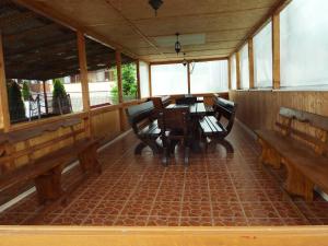 comedor con bancos de madera y mesa en Motel Flora, en Lepşa