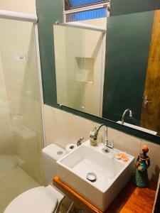 un bagno con lavandino, WC e specchio di Pousada Delicias da vila a Jericoacoara