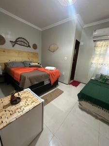 a bedroom with a bed and a table in it at Pousada Delicias da vila in Jericoacoara
