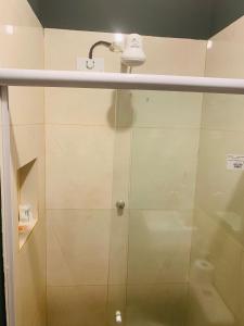 una doccia con porta in vetro e soffione di Pousada Delicias da vila a Jericoacoara