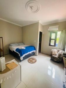 una camera da letto con un letto e una sedia di Pousada Delicias da vila a Jericoacoara