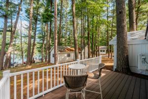 a deck with a table and chairs and trees at Backwoods Cottage on Arbutus Lake in Traverse City