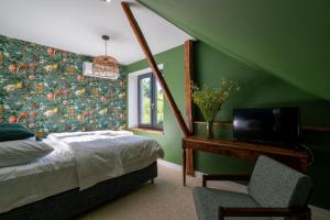 a bedroom with a bed and a desk with a television at Winnica Kosmos in Lubcza