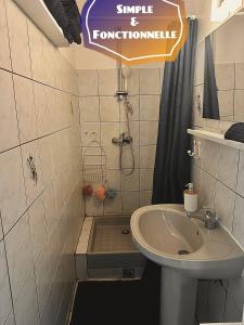 un bagno con lavandino e doccia con un cartello di F3 Famille ou Amis - Piscine, Vue Mer et Calme - Anse à l'Âne, 3-Îlets a Les Trois-Îlets