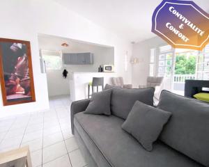 un soggiorno con divano e cucina di F3 Famille ou Amis - Piscine, Vue Mer et Calme - Anse à l'Âne, 3-Îlets a Les Trois-Îlets
