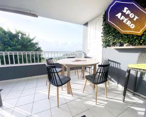 un patio con tavolo e sedie su un balcone di F3 Famille ou Amis - Piscine, Vue Mer et Calme - Anse à l'Âne, 3-Îlets a Les Trois-Îlets