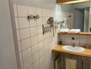 a bathroom with a sink and a mirror at Logis Hotel & Restaurant - Hostellerie du Prieuré in Saint-Quirin