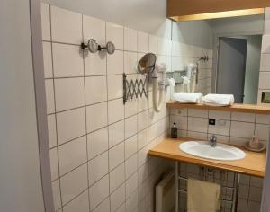 a bathroom with a sink and a mirror at Logis Hotel & Restaurant - Hostellerie du Prieuré in Saint-Quirin