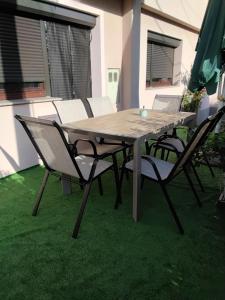 a wooden table and chairs on the grass at Apartman Aldina in Bihać +7 photos