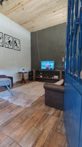 a living room with a couch and a tv at Rancho Vô de Ochinho in Sapucaí-Mirim +36 photos