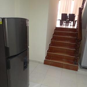 a refrigerator in a room with a staircase with chairs at Apartamento frente al mar y la playa Rodadero in Rodadero