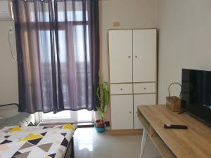 a living room with a bed and a television at Studio Condo at Saekyung Looc in Lo-oc