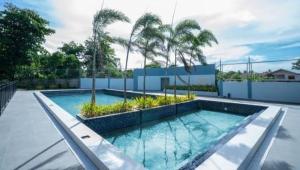 a swimming pool with palm trees in a backyard at Studio Condo at Saekyung Looc in Lo-oc