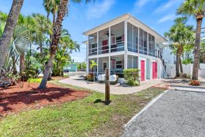 een huis met palmbomen ervoor bij Casita Coconut – Pool, Grill, Pet Friendly, Located in the Heart of SK! in Siesta Key