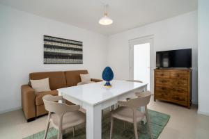 a living room with a white table and chairs at Villademar lunarossa in Marzamemi